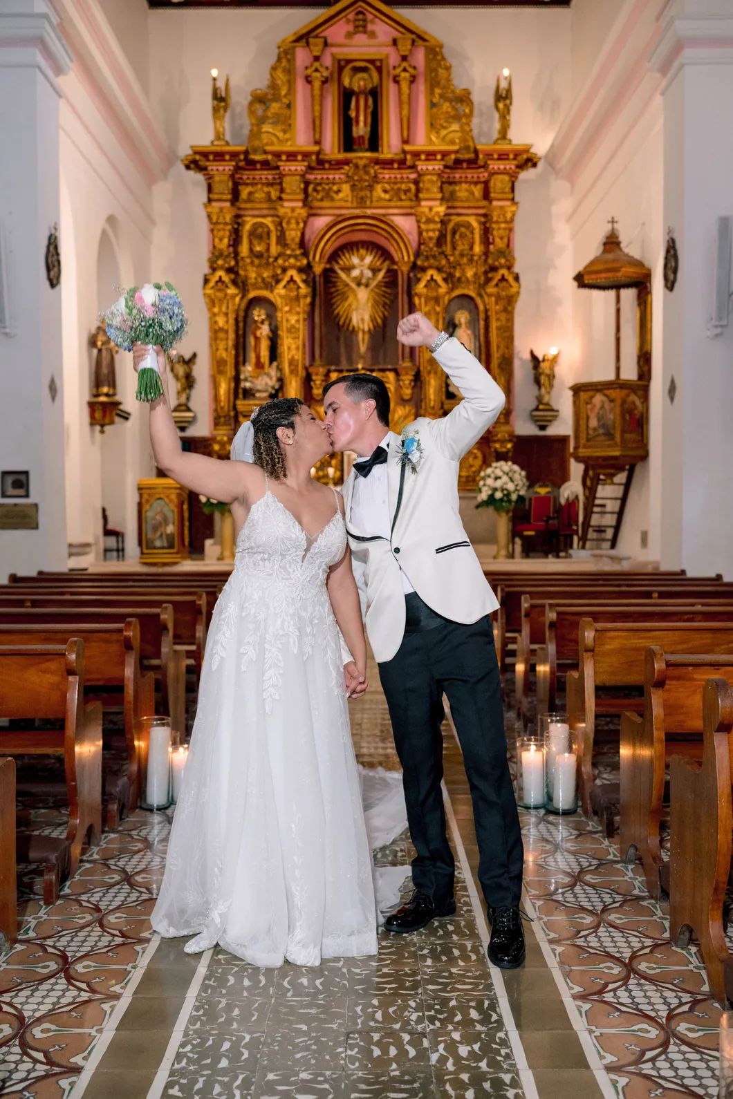 Los novios se besan en el pasillo de la iglesia tras la ceremonia, en Cartagena, por Omar Fraija